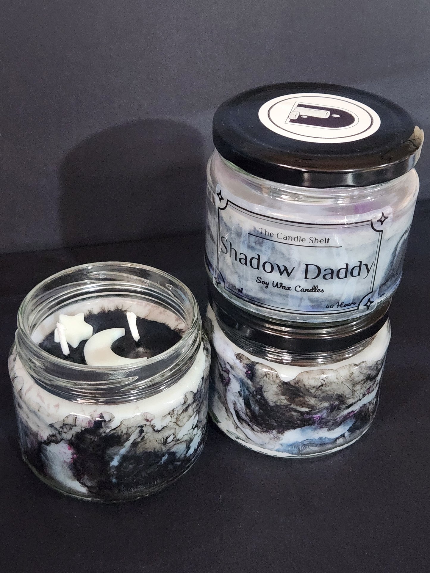 The Candle Shelf. Handmade Custom Bookish Soy Wax Candles inspired by those unforgettable moments between the pages. Beautifully marbled glass container jar candles. Shadow Daddy, Star Dust, The Last Page. Pillar candles. Book candle. Heats candle. Forest, floral and leaves candle. Their fancy and deliciously scented. The perfect decor item for your home, office, wedding or even as a gift. We offer customised labels and candle colours. Each candle is made to order.  All candles are made from NZ sourced wax.